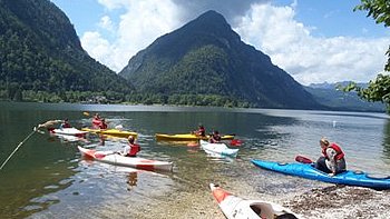 The participants of the lake kayak course in their lake kayaks at Lake Hallstatt (photo: Gerhard Gschwendtner)
